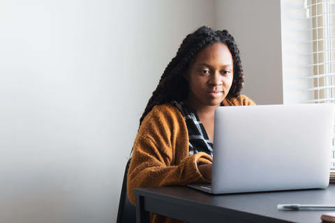 Female student sitting at a desk working on laptop 